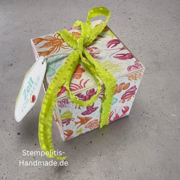 Handdekorierte Fensterschachtel 7 cm mit maritimen Motiven, Geschenkbox mit Fenster und Schleife in Grün, Detailansicht Geschenkschachtel Etikett „Zeit für Meer“, Offene Sichtfensterbox von oben, Fensterschachtel mit bunter Meeresdekoration, Geschenkverpackung mit transparentem Fenster, Handgemachte maritime Fensterschachtel mit Schleife